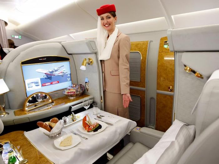  Đồng phục đặc trưng của tiếp viên hàng không Emirates với mũ đỏ và dải khăn voan trắng buông từ mũ. Ảnh: Reuters.