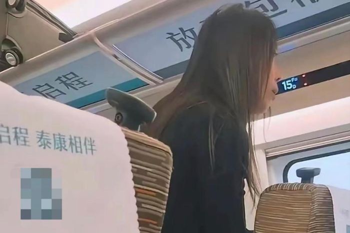 Nữ hành khách yêu cầu người ngồi sau kết thúc cuộc gọi. Ảnh: QQ.