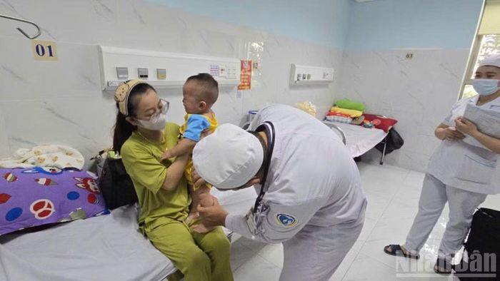 Khám và điều trị một bệnh nhi mắc bệnh tay chân miệng. (Ảnh: THANH DŨNG)