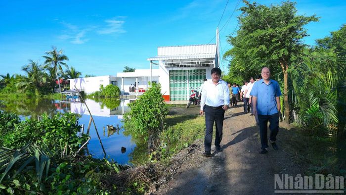 Đồng chí Nguyễn Hồ Hải, Ủy viên Trung ương Đảng, Bí thư Tỉnh ủy Cà Mau (bìa phải) thị sát lộ nông thôn chưa cứng hóa mặt đường trên địa bàn xã Khánh An, tỉnh Cà Mau. (Ảnh: HỮU TÙNG)