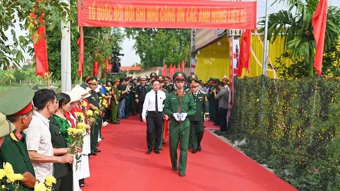 Đông đảo cán bộ và nhân dân mang theo hoa và Quốc kỳ, trang nghiêm tiễn đưa, thể hiện lòng biết ơn đối với các liệt sĩ và đồng bào đã ngã xuống. (Ảnh: ĐỨC NGHĨA)