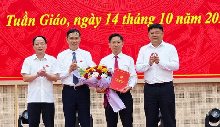 Các đồng chí lãnh đạo Đảng ủy, Ủy ban nhân dân xã Tuần Giáo tặng hoa, chúc mừng đồng chí Phạm Sóng Hoàng Long. (Ảnh: BÍCH HẠNH)