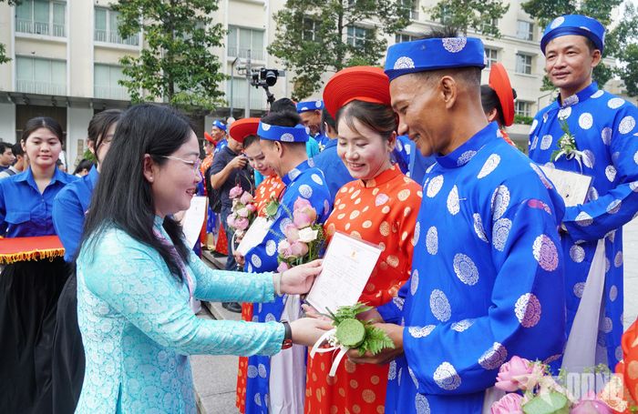 Lãnh đạo Liên đoàn Lao động TP Hồ Chí Minh trao giấy chứng nhận đăng ký kết hôn đến các cặp đôi. 