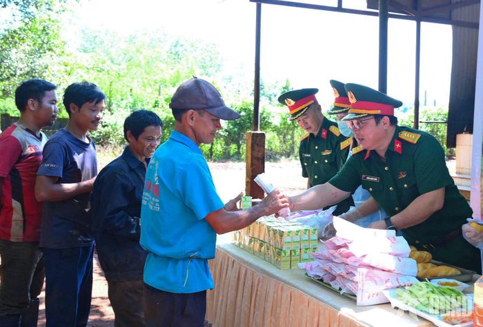 Đại tá Huỳnh Xuân Phước, Đoàn trưởng Đoàn Kinh tế - Quốc phòng 715 trao bánh mì và sữa tới người lao động.  
