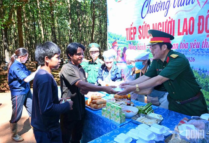 Đại tá Hoàng Đức Tỏa, Bí thư Đảng ủy, Phó đoàn trưởng Đoàn Kinh tế - Quốc phòng 715 trao xôi và sữa tới người lao động. 