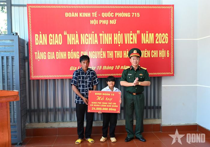 Đại tá Thái Bá Mão, Phó chủ nhiệm Chính trị Binh đoàn 15 trao bảng tượng trưng hỗ trợ tiền cho cháu Rơ Châm Nuôi.
