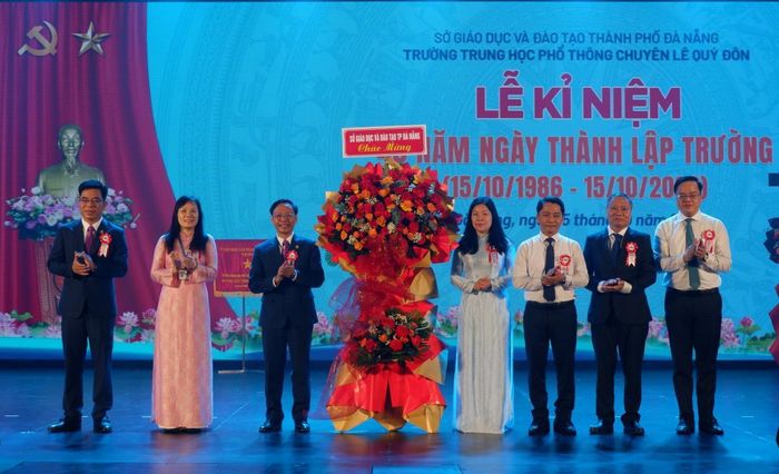 Lãnh đạo Sở GD-ĐT (bên phải) tặng hoa chúc mừng nhà trường. Ảnh: P.T
