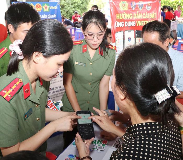  Công an phường An Hội Tây (TPHCM) hướng dẫn người dân sử dụng ứng dụng VNeID. Ảnh: NGÔ BÌNH 