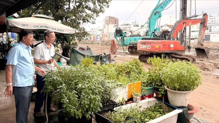 Ông Lê Hữu Phú (bên trái) trao đổi với ông Bùi Thành Phát (ngụ hẻm 220 Nguyễn Xí) về cuộc sống và dự án rạch Xuyên Tâm. Ảnh: THÁI PHƯƠNG
