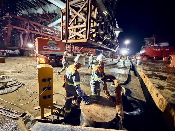Công nhân kiểm tra dây cáp, thiết bị phục vụ việc đưa kết cấu vòm thép xuống sà lan. Ảnh: HOÀNG HÙNG