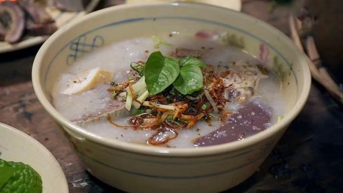 Nếu muốn khám phá thêm nét riêng trong ẩm thực vùng Bảy Núi, cháo bò Tri Tôn là món ăn không nên bỏ lỡ. Cháo có độ dẻo thơm, nước dùng ngọt từ xương bò, kết hợp với thịt bò, lòng bò và huyết. Điểm nhấn đặc biệt nằm ở vị chua thanh nhẹ của trái chúc, hòa cùng gừng thái sợi, hành lá và ớt, tạo nên hương vị đậm đà đặc trưng. Ảnh: ivivu