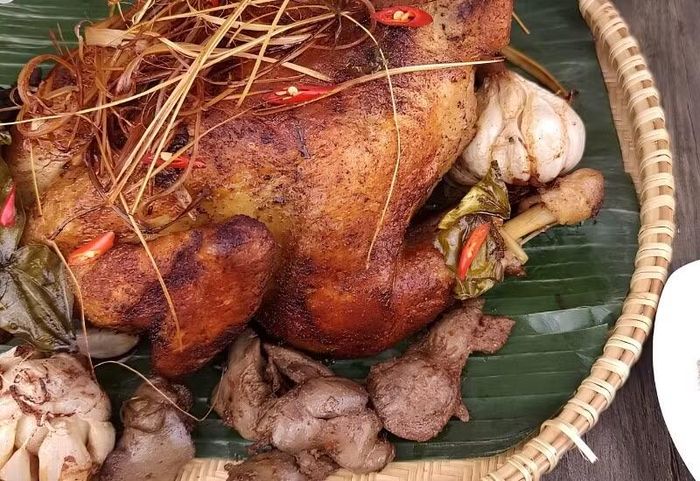 Không chỉ có các món nước, An Giang còn nổi tiếng với gà đốt lá chúc Ô Thum. Gà được tẩm ướp sả, ớt, tỏi rồi đốt trong nồi đất cùng lá chúc, giúp thịt giữ được độ mềm ngọt và lớp da vàng óng hấp dẫn. Hương thơm đặc trưng của lá chúc khiến món ăn trở nên khác biệt, nhất là khi dùng cùng xôi đậu xanh, rau rừng và muối tiêu chanh. Ảnh: Arttimes