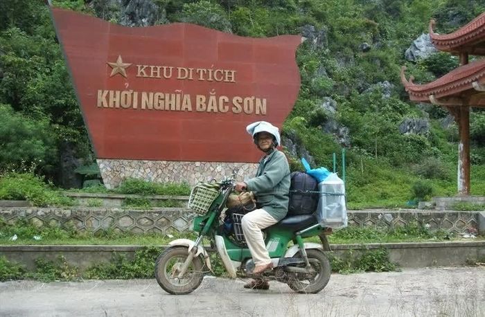 Họa sĩ Đặng Ái Việt trên chiếc xe máy nhỏ (Chaly) với hành trang trên vai là những hộp màu và cây cọ. (Nguồn: VNP)
