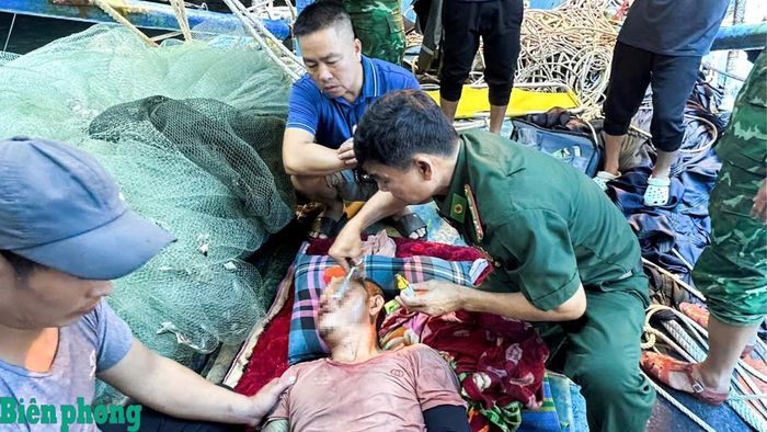Cán bộ quân y Đồn Biên phòng Roòn sơ cứu thuyền viên bị thương nặng. Ảnh: Ngọc Hòa