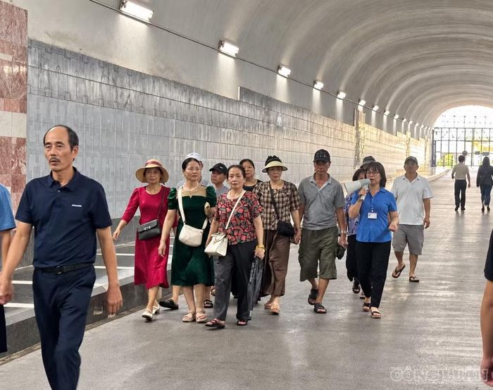 Một đoàn khách theo hướng dẫn viên tiến vào khu vực nhà máy. Các nhóm tham quan di chuyển theo tuyến và được phổ biến quy định an toàn