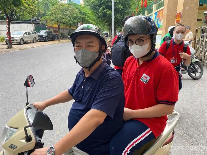 Ông Quang và cháu trai đội mũ bảo hiểm, cài quai đúng cách khi đi xe máy. Ảnh: Kim Tuyến