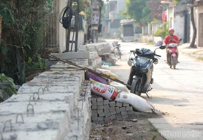 Tại một số vị trí, các hộ dân phải đặt bao tải cát, ghép ván gỗ hoặc tận dụng cánh cửa cũ làm cầu tạm bắc qua rãnh để có lối đi vào nhà.