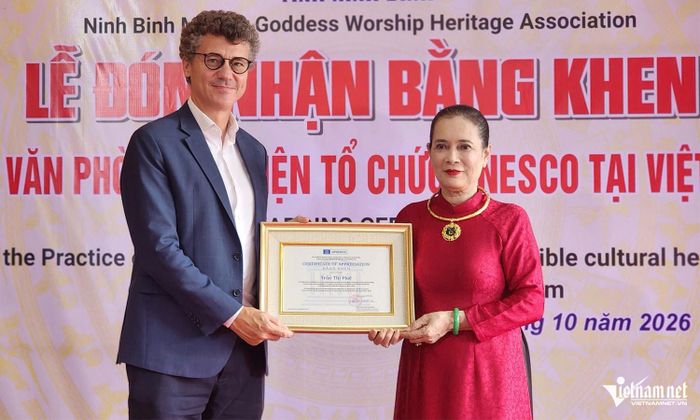 Ông Jonathan Wallace Baker trao tặng bằng khen cho Nghệ nhân Ưu tú Trần Thị Huệ - Thủ nhang Phủ chính Phủ Dầy. 