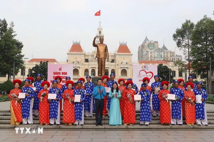 Phó Chủ tịch Liên đoàn Lao động TP. Hồ Chí Minh Nguyễn Kim Loan trao giấy đăng ký kết hôn cho các cặp đôi là đoàn viên Công đoàn, hội viên, thanh niên công nhân, viên chức, người lao động tham gia “Lễ cưới tập thể” năm 2026. (Ảnh: Thanh Vũ/TTXVN)