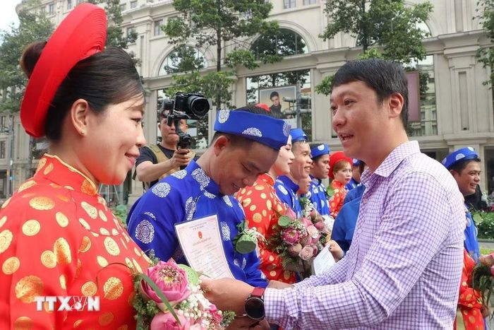 Lãnh đạo Sở Văn hóa Thể thao TP. Hồ Chí Minh trao giấy đăng ký kết hôn cho các cặp đôi là đoàn viên Công đoàn, hội viên, thanh niên công nhân, viên chức, người lao động tham gia “Lễ cưới tập thể” năm 2026. (Ảnh: Thanh Vũ/TTXVN)