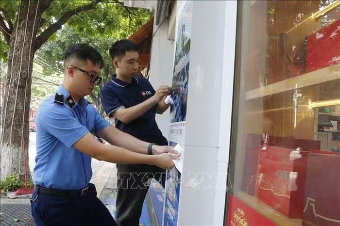 Lực lượng chức năng yêu cầu các cơ sở gỡ bỏ các biển hiệu chưa phù hợp tại phường Kinh Bắc, thành phố Bắc Ninh. Ảnh: Thái Hùng/TTXVN