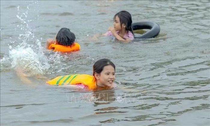 Các em nhỏ tung tăng bơi lội trên cánh đồng ngập nước ở khu vực Cống Bùng Rền, ấp Vĩnh Lợi, xã Phú Hữu (tỉnh An Giang) trải nghiệm tắm đồng mùa nước nổi.