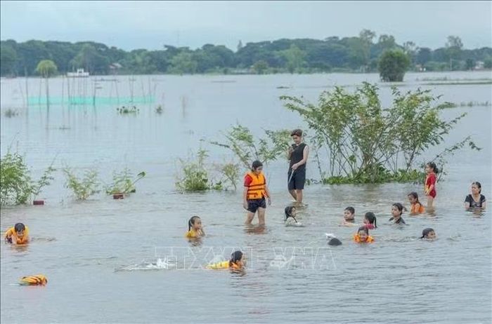 Người dân trải nghiệm tắm đồng mùa nước nổi ở khu vực Cống Bùng Rền, ấp Vĩnh Lợi, xã Phú Hữu, tỉnh An Giang.
