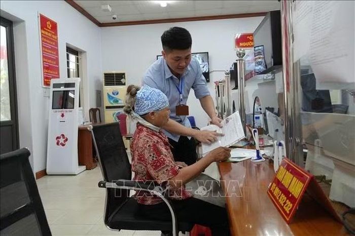 Ông Phạm Quang Huy, Phó Giám đốc Trung tâm Phục vụ hành chính công xã Yên Mỹ (Hưng Yên) hướng dẫn người dân kê khai, nộp hồ sơ. Ảnh: Mạnh Khánh/TTXVN