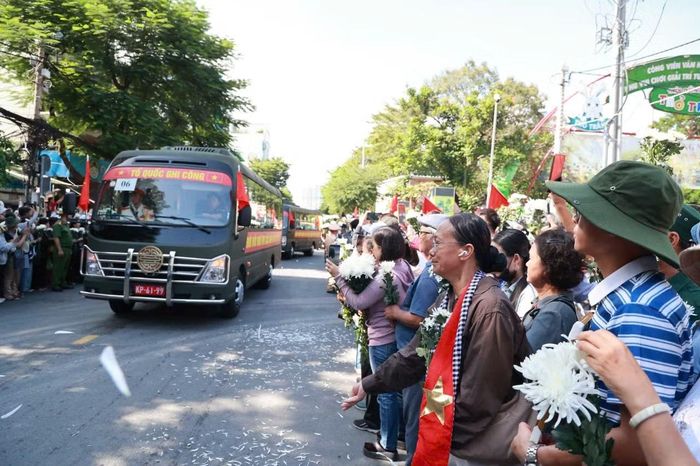 Đông đảo người dân TP Hồ Chí Minh với bông cúc trắng trên tay tiễn các liệt sĩ. Ảnh: Mạnh Linh