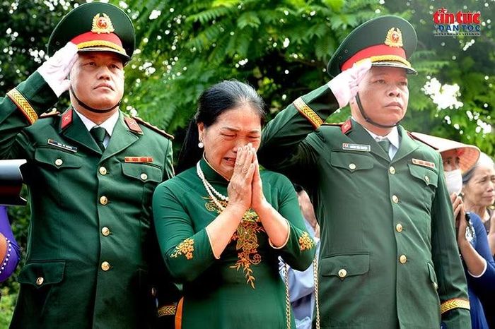 Người phụ nữ không kìm được nước mắt trong giây phút tiễn đưa các liệt sĩ.