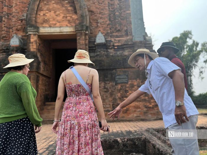 Ông Trung (bên phải ảnh) giới thiệu văn hóa Champa cho đoàn famtrip đến từ Úc tại Di tích Tháp Đôi.