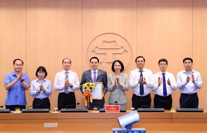 Lãnh đạo thành phố Hà Nội và Sở Y tế Hà Nội chúc mừng tân Phó Giám đốc Sở Y tế Nguyễn Đức Long. Ảnh: Diệu Linh.