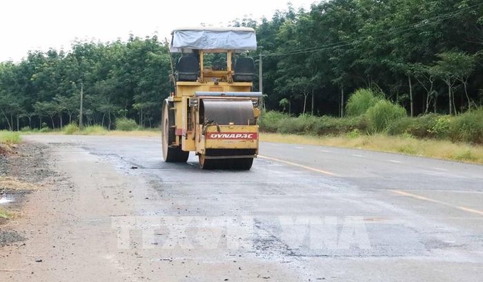 Thi công mặt đường hư hỏng trên tuyến ĐH 312 qua xã Phú Trung, thành phố Đồng Nai. Ảnh: Đậu Tất Thành - TTXVN