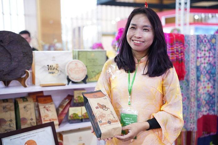 Bà Nguyễn Thị Thắm, Giám đốc Công ty trà và đặc sản Tây Bắc, giới thiệu sản phẩm trà tại một hội chợ xúc tiến thương mại. Ảnh: Phương Lan.