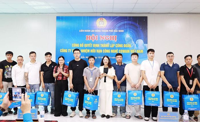  Đồng chí Chu Thị Thu Hương và bà Dương Thị Hải Vân trao quà của Liên đoàn Lao động thành phố cho các đoàn viên của Công đoàn cơ sở Công ty trách nhiệm hữu hạn Công nghệ Cowain Việt Nam. 