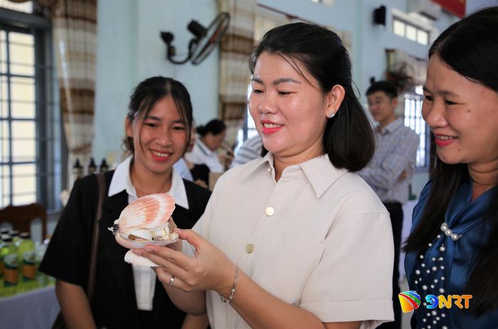 Du khách thích thú với sản phẩm được chế tạo từ nguyên liệu thiên nhiên của vùng biển Quảng Phú. Ảnh: ALĂNG NGƯỚC