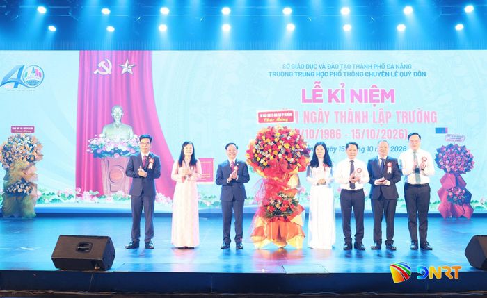 Lãnh đạo Sở Giáo dục và Đào tạo (bên phải) tặng hoa chúc mừng nhà trường. Ảnh: NGỌC HÀ