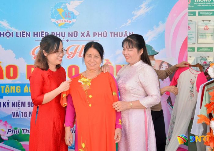 Chia sẻ với phụ nữ khó khăn tại gian hàng “Áo dài 0 đồng”. Ảnh: LAM KHUÊ
