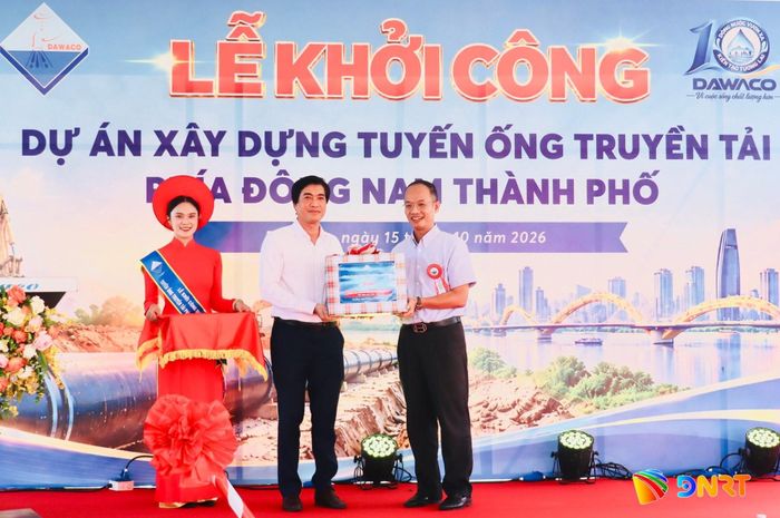 Đại diện Công ty CP Cấp nước Đà Nẵng (giữa) tặng quà động viên đơn vị nhà thầu thi công dự án. Ảnh: QUỐC TUẤN
