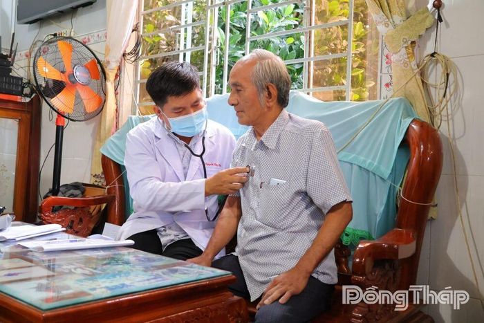 Nhân viên y tế khám sức khỏe cho người cao tuổi tại nhà trong đợt cao điểm chăm sóc sức khỏe, tích hợp các tiện ích số ở xã Mỹ Hiệp.