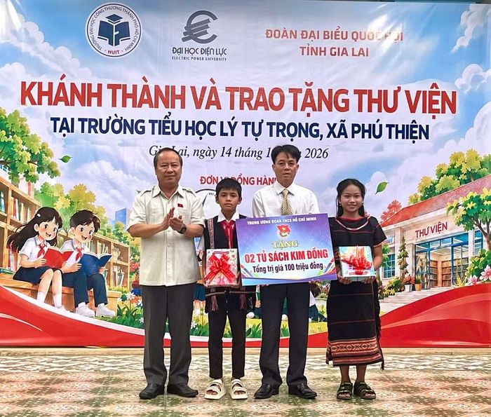  Phó Bí thư Tỉnh ủy, Trưởng Đoàn đại biểu Quốc hội tỉnh Châu Ngọc Tuấn (bên trái) trao bảng tượng trưng tặng 2 tủ sách Kim Đồng cho Trường Tiểu học Lý Tự Trọng. Ảnh: Phương Dung 
