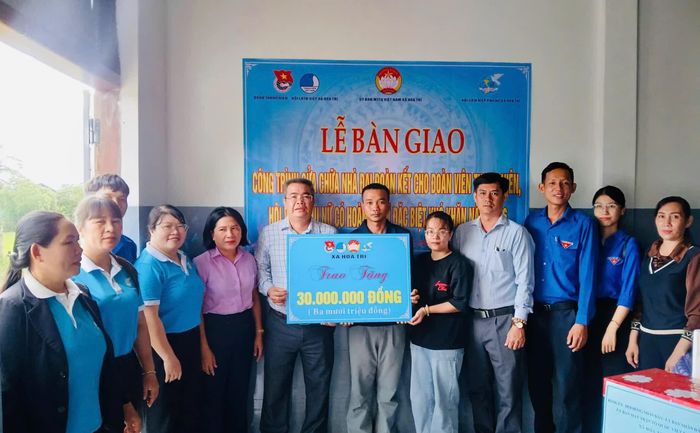 Đại diện các đơn vị trao bảng tượng trưng hỗ trợ kinh phí cho gia đình ông Nguyễn Thành Tấn.