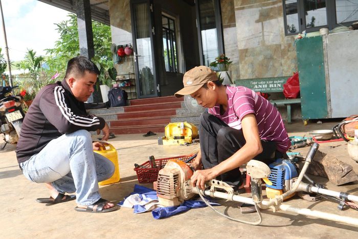 Bị teo cơ bẩm sinh, anh Đinh Văn Tín (bên phải), xã Nam Đà từng bước vượt qua mặc cảm gây dựng tiệm sửa chữa, mua bán máy móc nông nghiệp để phát triển kinh tế