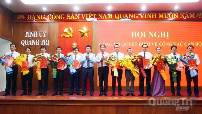 Đồng chí Trần Vũ Khiêm, Phó Bí thư Thường trực Tỉnh ủy và đồng chí Hoàng Nam, Phó Chủ tịch Thường trực UBND tỉnh trao quyết định, tặng hoa chúc mừng các cán bộ được điều động, chỉ định, bổ nhiệm - Ảnh: N.M