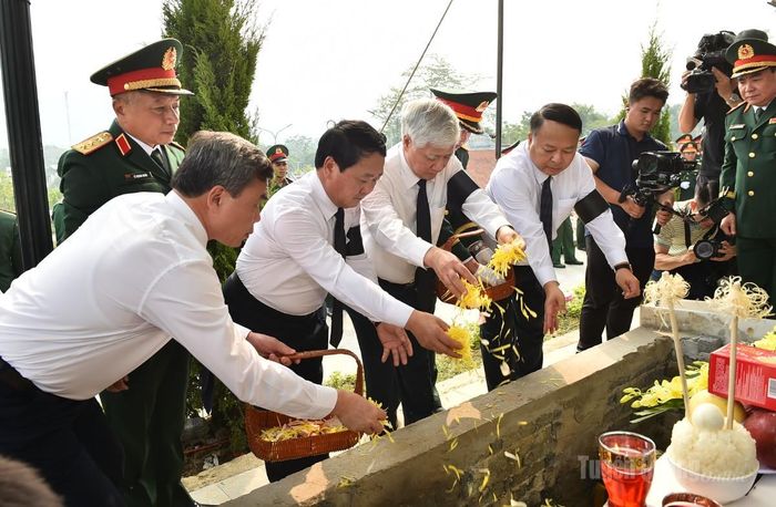 Các đại biểu thực hiện nghi lễ thả hoa xuống mộ liệt sĩ.