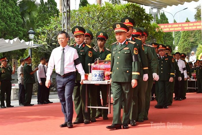 Đồng chí Nguyễn Văn Sơn, Chủ tịch HĐND tỉnh và lãnh đạo Bộ Quốc phòng di chuyển hài cốt liệt sĩ.