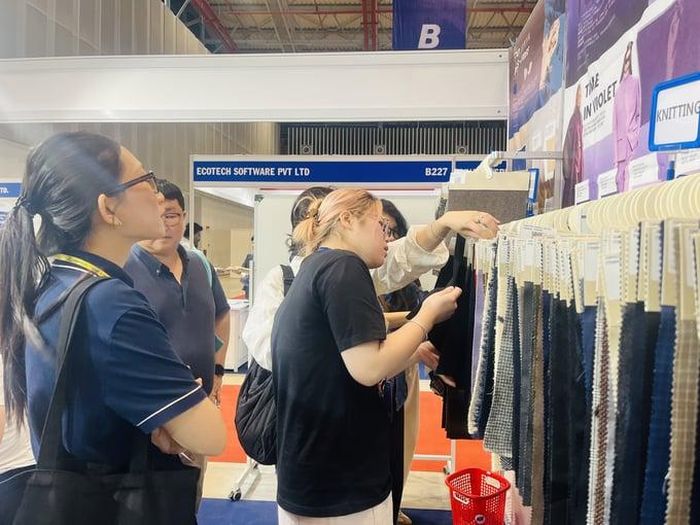 Khách tham quan tìm hiểu các mẫu vải và vật liệu mới.