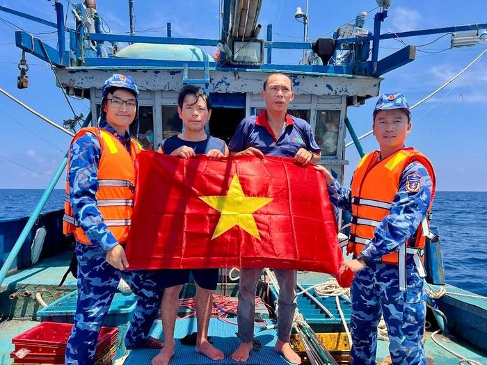 Cán bộ, chiến sĩ tàu 364 Cảnh sát biển Việt Nam tuyên truyền pháp luật, tặng cờ Tổ quốc cho ngư dân trên biển. Ảnh: Cảnh sát biển Việt Nam