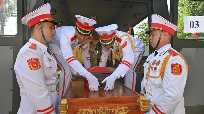 Chiến sĩ đội danh dự cẩn trọng đặt tiểu quách hài cốt Liệt sĩ lên xe tại Công viên văn hóa Lê Thị Riêng