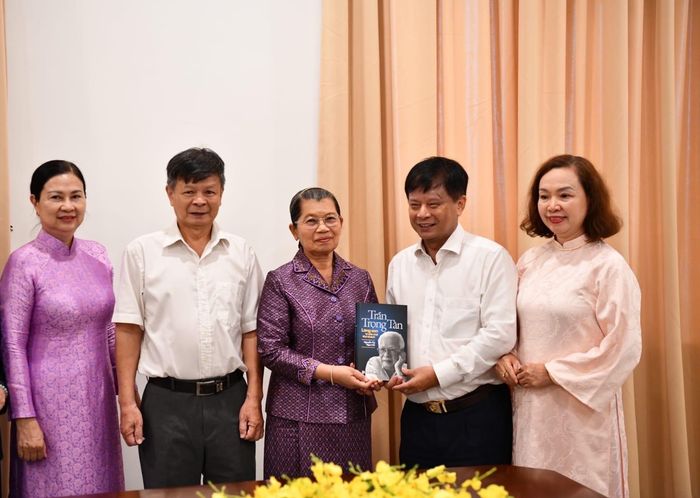 Ông Trần Trọng Dũng, Phó Chủ tịch Hội nhà báo Việt Nam, con trai của ông Trần Trọng Tân, thay mặt gia đình tặng cuốn sách của cha mình cho Samdech Men Sam An - Phó Chủ tịch Đảng Nhân dân Campuchia; Chủ tịch Hội đồng Quốc gia Mặt trận Đoàn kết phát triển Tổ quốc Campuchia. Ảnh: TFS